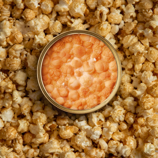 caramel popcorn scented candle in a gold tin