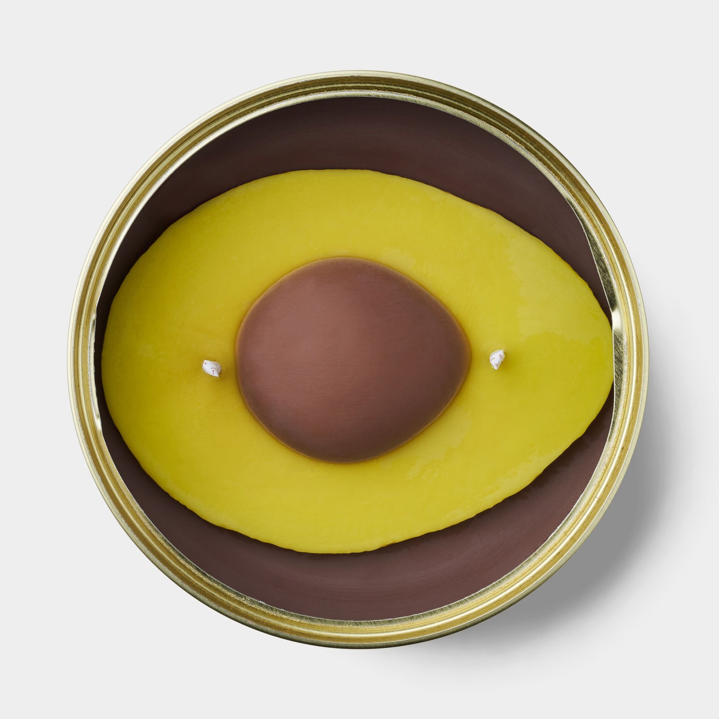 avocado shaped scented candle in a gold tin