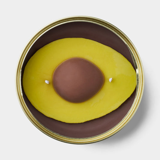 avocado shaped scented candle in a gold tin