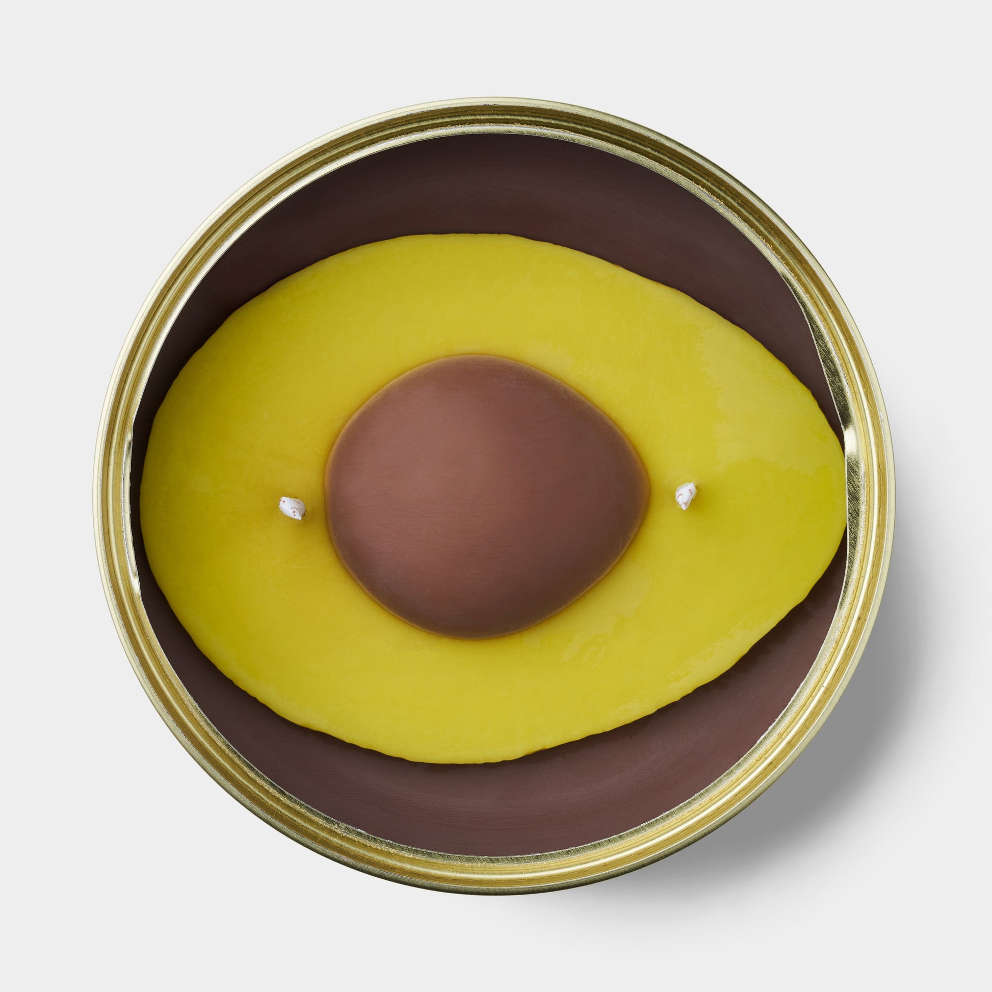 avocado shaped scented candle in a gold tin 