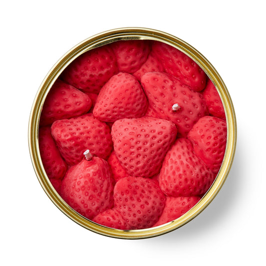 strawberry shaped scented candle in a gold tin on a white background